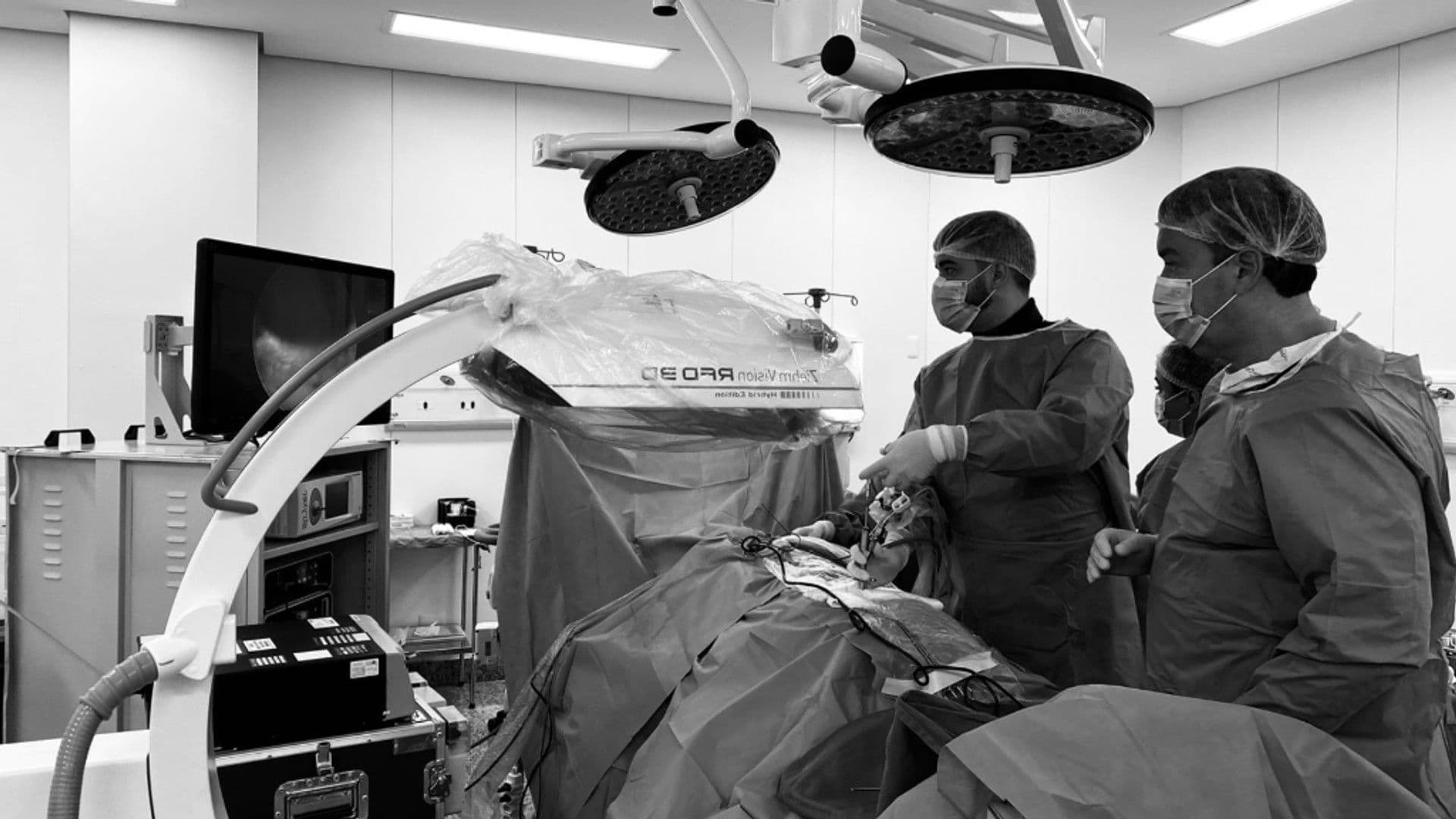 Dr. Rômulo Oliveira durante atendimento e cirurgia de coluna de alta precisão analisando as imagens em um monitor durante o procedimento em Betim